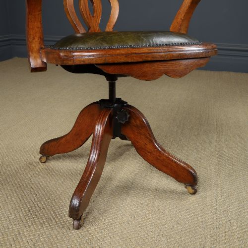 fig 2. An Edwardian oak revolving desk armchair featuring a carved pierced back splat, green leather upholstered seat with close studding, and a four-point swivel base on brass castors.