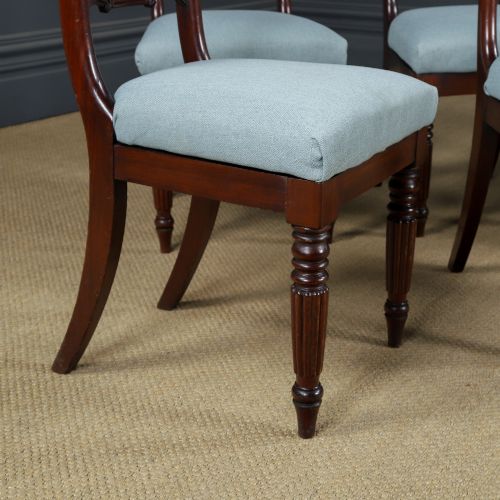 fig 1. A set of six antique mahogany dining chairs featuring curved top rails, carved horizontal splats, fluted turned front legs, and light blue upholstered seats.