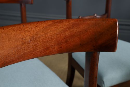 fig 5. A set of six antique mahogany dining chairs featuring curved top rails, carved horizontal splats, fluted turned front legs, and light blue upholstered seats.