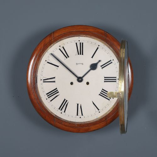 fig 1. A circular Smiths antique wall clock with a turned mahogany wood surround, off-white dial with black Roman numerals, brass hinged bezel, and winding holes.