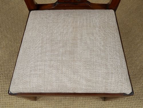 fig 3. A Georgian mahogany side chair with a pierced carved back splat, square legs connected by stretchers, and a neutral textured seat upholstery.