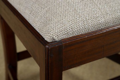 fig 4. A Georgian mahogany side chair with a pierced carved back splat, square legs connected by stretchers, and a neutral textured seat upholstery.