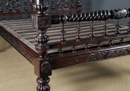fig 1. An Anglo-Indian mahogany four poster bed featuring carved turned posts, an ornate headboard, and a spindle footboard.