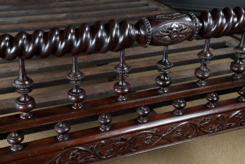 fig 5. An Anglo-Indian mahogany four poster bed featuring carved turned posts, an ornate headboard, and a spindle footboard.