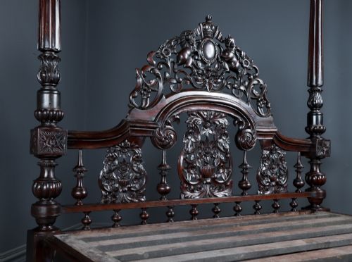 fig 9. An Anglo-Indian mahogany four poster bed featuring carved turned posts, an ornate headboard, and a spindle footboard.