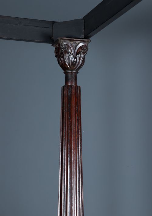 fig 11. An Anglo-Indian mahogany four poster bed featuring carved turned posts, an ornate headboard, and a spindle footboard.