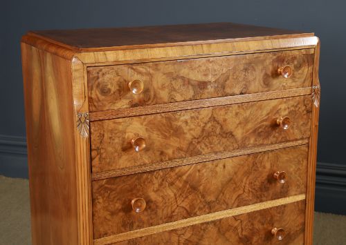 fig 2. An Art Deco chest of drawers in figured burr walnut featuring six graduated drawers with turned wooden handles and carved shoulder details.