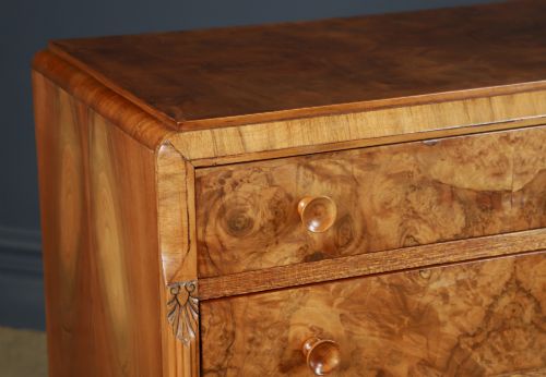 fig 3. An Art Deco chest of drawers in figured burr walnut featuring six graduated drawers with turned wooden handles and carved shoulder details.