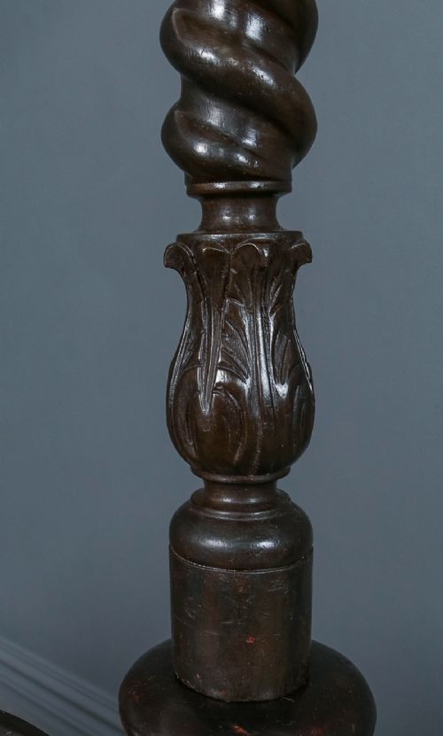 fig 6. An antique dark timber king-size four-poster bed featuring spiral turned posts, a carved footboard with circular cut-out details, and an upper canopy frame.