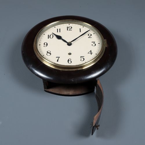 fig 4. A circular antique dark mahogany wall clock featuring a white dial with black Arabic numerals and a brass bezel.
