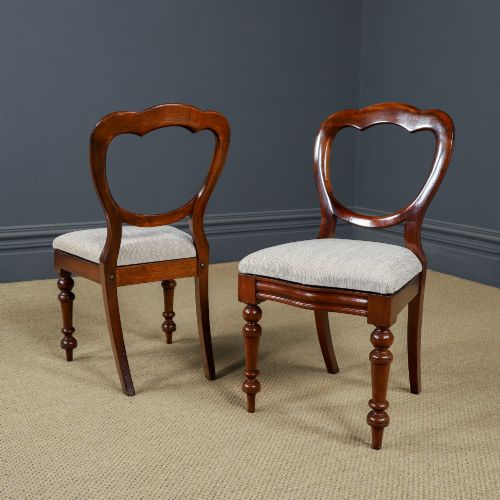 fig 1. A pair of mid-nineteenth century Victorian mahogany dining chairs featuring balloon back frames, turned front legs, and neutral fabric upholstered seats.