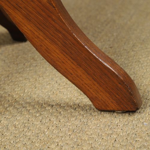fig 3. A George V period golden oak revolving desk chair featuring a curved spindle backrest, quadruped base, and a padded green leather seat secured with brass studs.