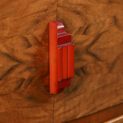 fig 4. An Art Deco figured walnut dressing table featuring twin pedestal drawers, a central curved drawer, red handles, and a three-panel upright mirror.