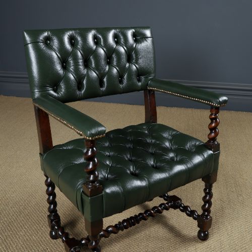 fig 1. An antique 17th-century style dark oak armchair featuring deep-buttoned green leather upholstery, brass stud trim, and barley-twist turned legs and stretchers.
