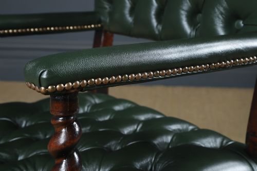 fig 6. An antique 17th-century style dark oak armchair featuring deep-buttoned green leather upholstery, brass stud trim, and barley-twist turned legs and stretchers.