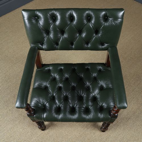 fig 7. An antique 17th-century style dark oak armchair featuring deep-buttoned green leather upholstery, brass stud trim, and barley-twist turned legs and stretchers.