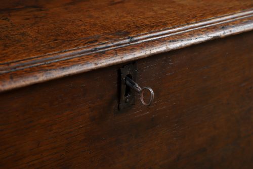 fig 2. A rectangular dark brown oak six-plank coffer featuring V-cut side legs and iron keyhole escutcheon detail.