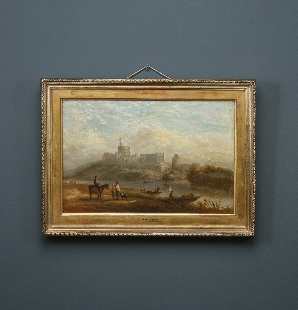 A 19th-century framed oil painting depicting Windsor Castle across a river with figures and a horse in the foreground, set within a gilded moulded frame with an artist nameplate.