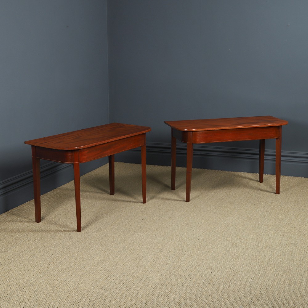 A pair of Georgian mahogany D-shaped console tables standing on square tapered legs.