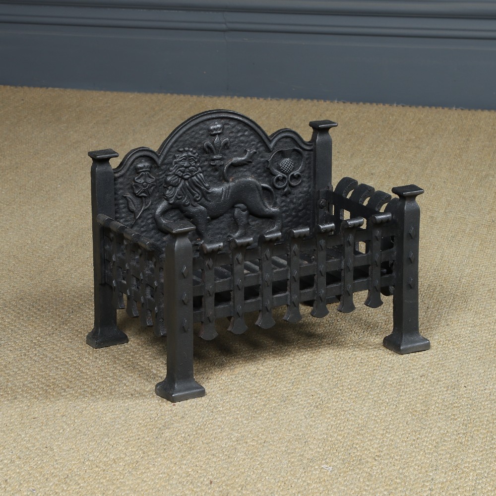 A black cast iron fire grate featuring a relief-carved heraldic lion backplate and portcullis lattice front basket.