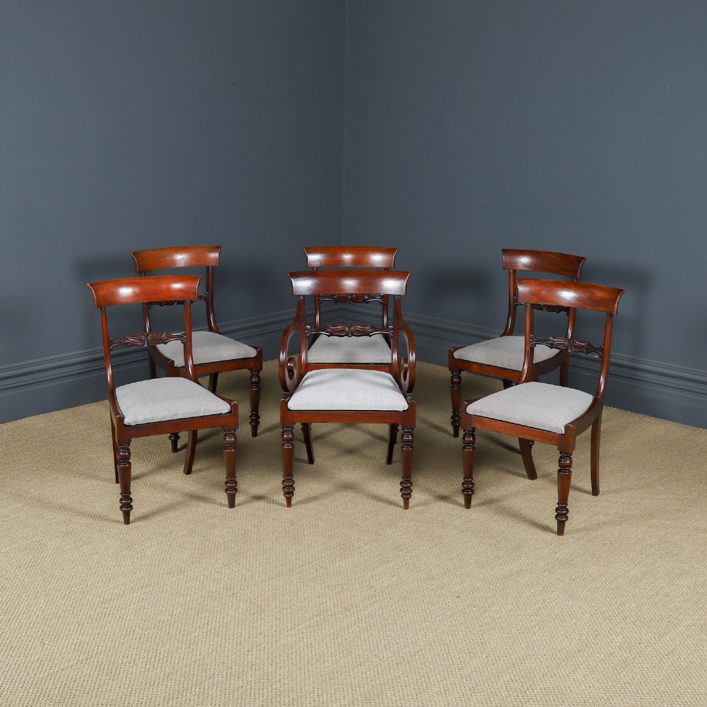 A set of six mahogany Regency dining chairs featuring carved back rails, turned front legs, and light-coloured upholstered seats.