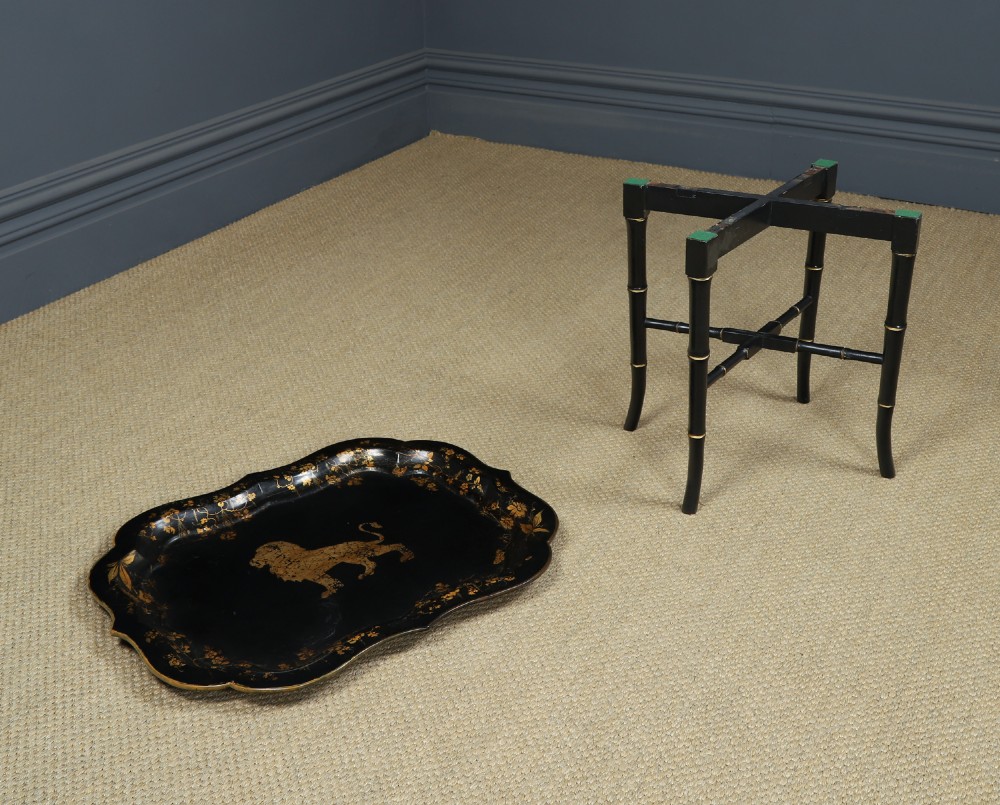 An ebonised Victorian papier-mache tray table featuring gilt Chinoiserie decoration and a lion motif, resting on a faux-bamboo base. View XI
