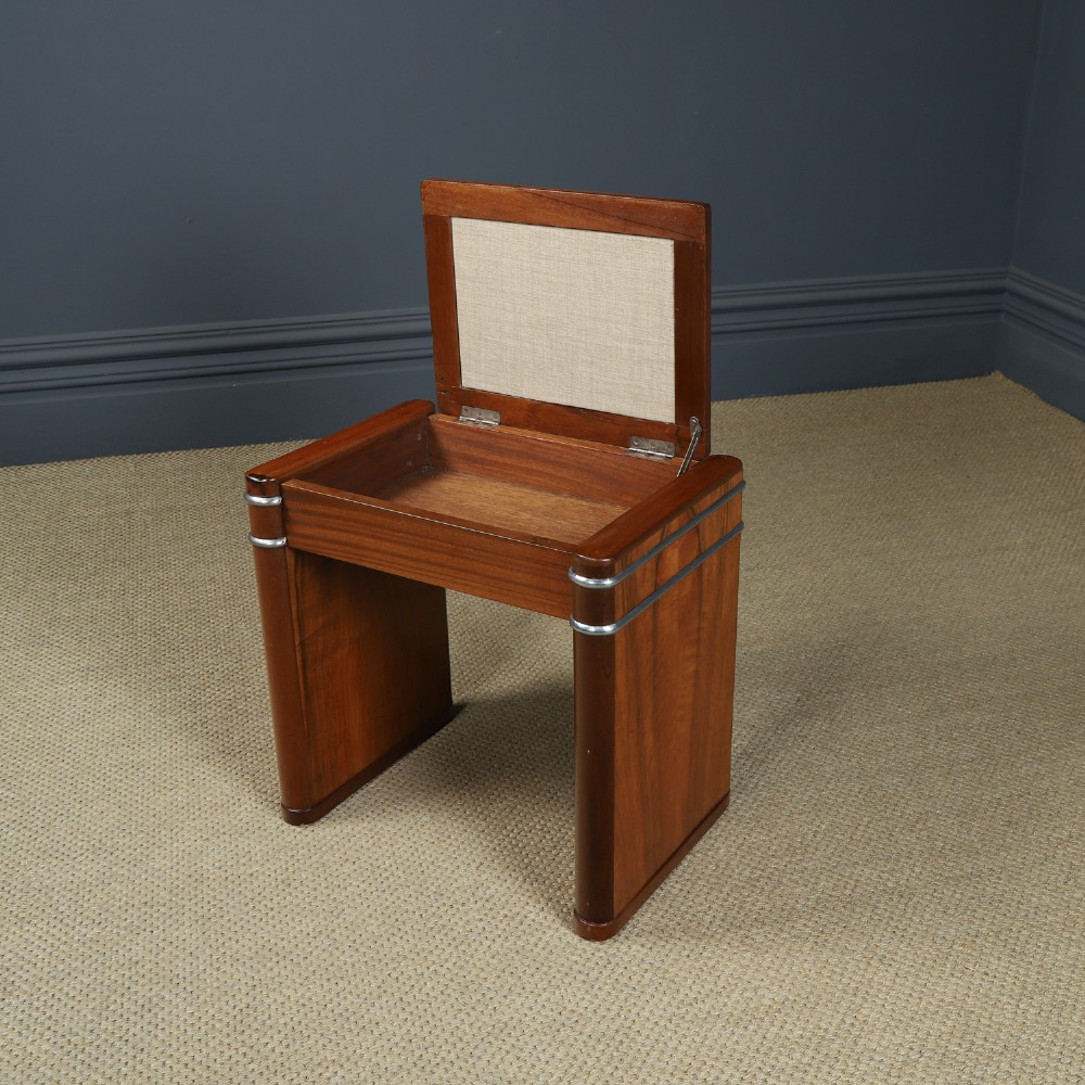 An Art Deco rectangular walnut stool featuring slab legs with metal band accents and a cream leather padded seat. View VIII