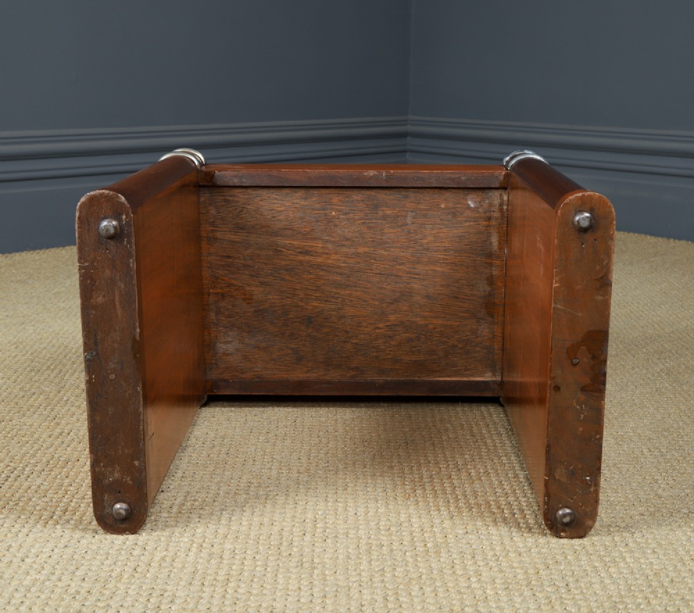 An Art Deco rectangular walnut stool featuring slab legs with metal band accents and a cream leather padded seat. View X