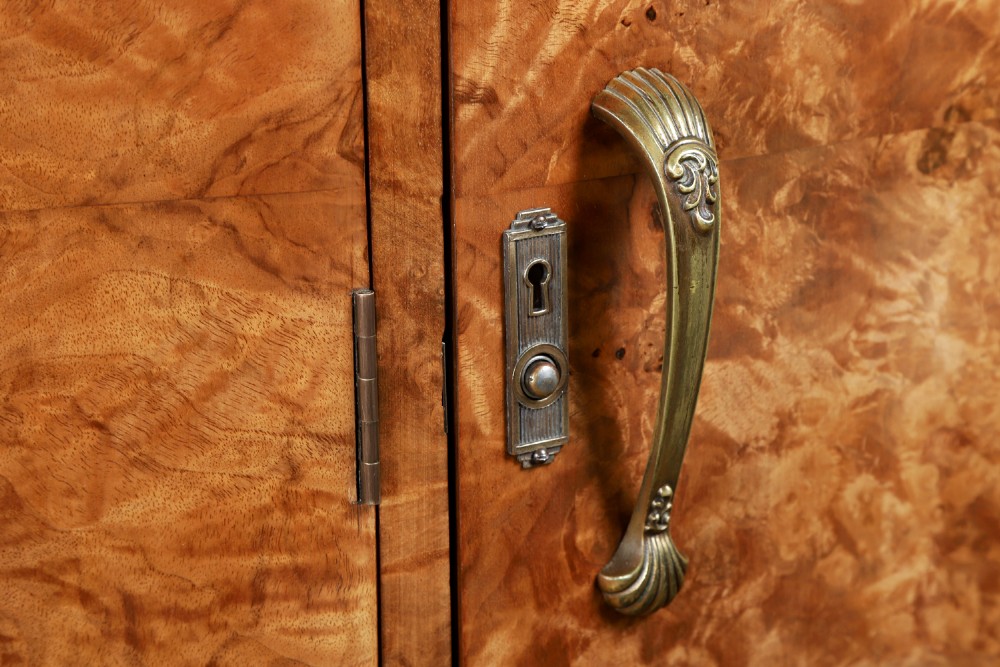 An English Art Deco triple-door wardrobe crafted from figured burr walnut with curved sides and vertical handles. View IV