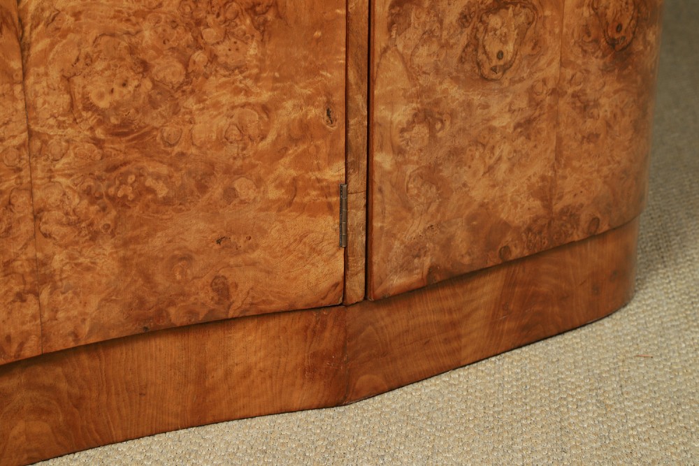 An English Art Deco triple-door wardrobe crafted from figured burr walnut with curved sides and vertical handles. View V