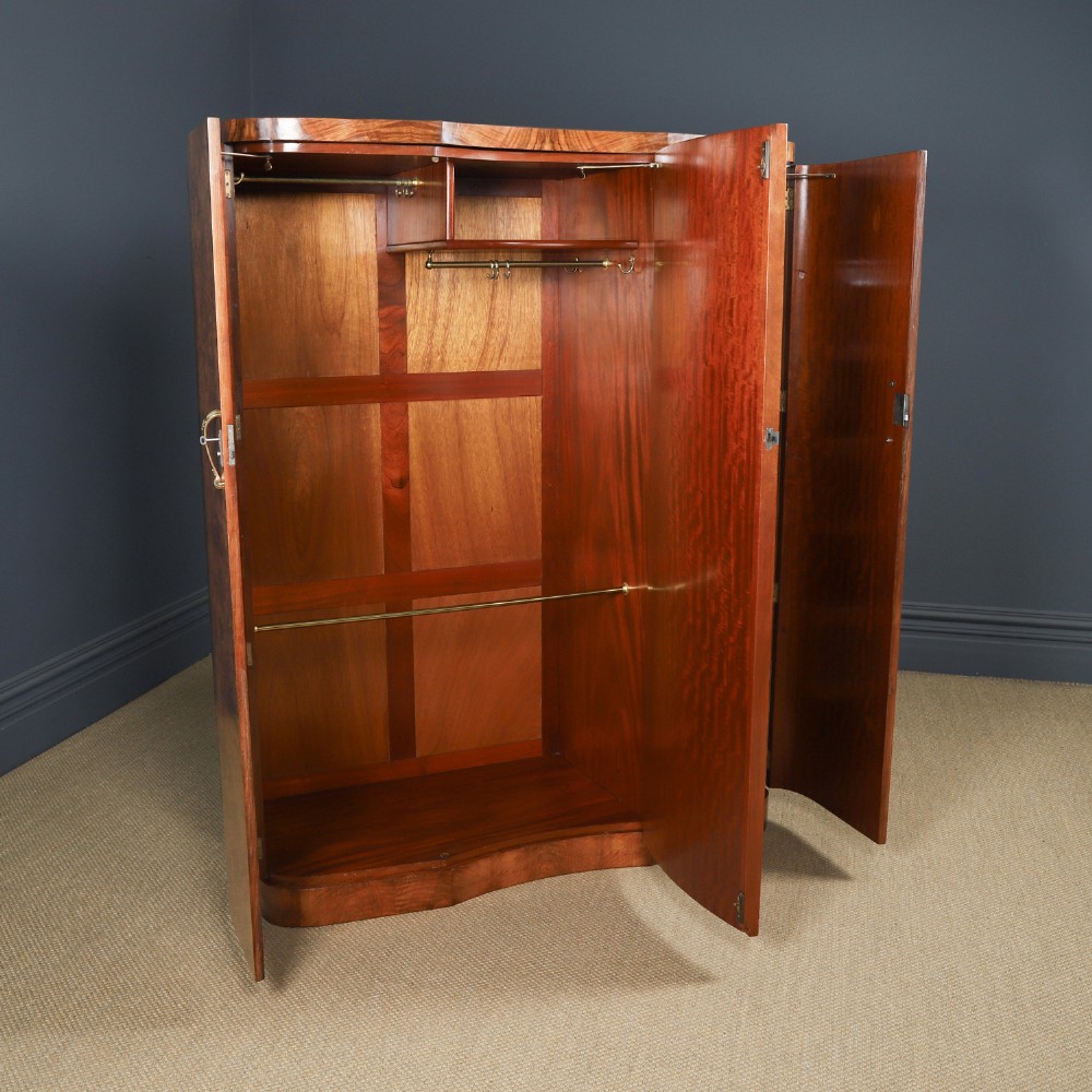 An English Art Deco triple-door wardrobe crafted from figured burr walnut with curved sides and vertical handles. View VII