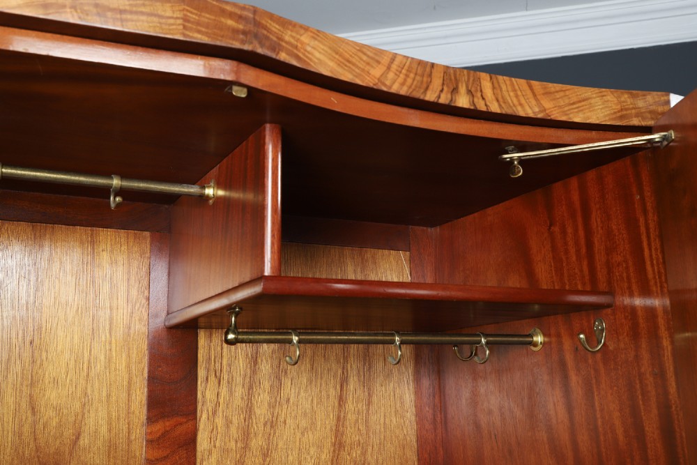 An English Art Deco triple-door wardrobe crafted from figured burr walnut with curved sides and vertical handles. View VIII