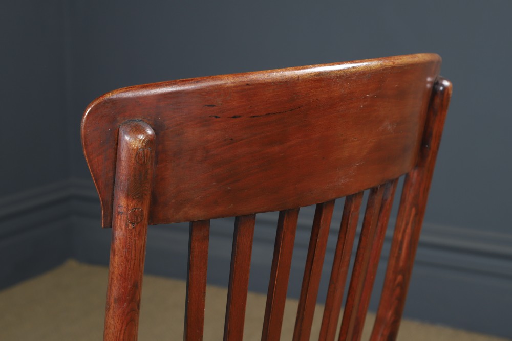 An antique George V stained beech revolving office chair featuring a slatted backrest, green leather seat, and splayed legs on brass castors. View IX