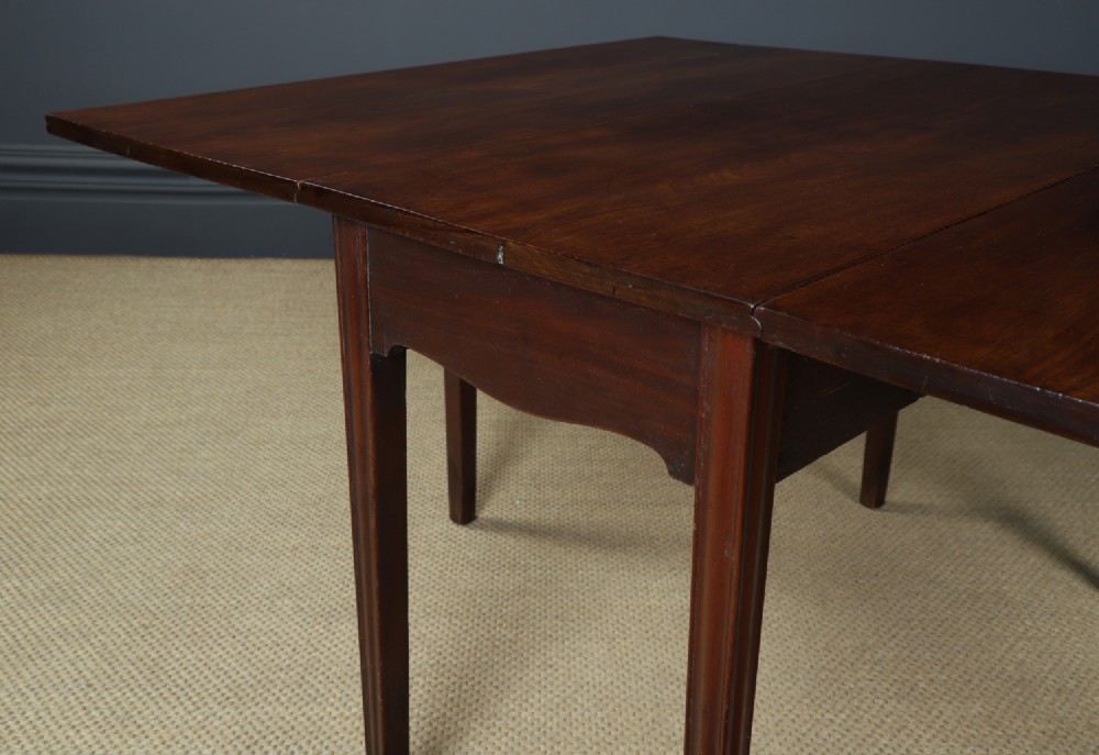 A Georgian mahogany drop-leaf dining table shown fully extended with rectangular flaps, a shaped apron, and straight square legs. View VI