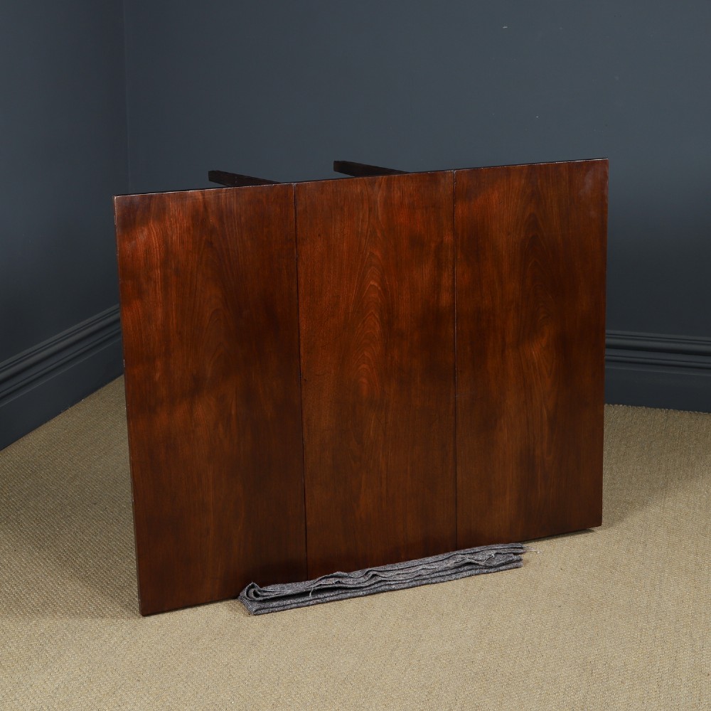 A Georgian mahogany drop-leaf dining table shown fully extended with rectangular flaps, a shaped apron, and straight square legs. View X