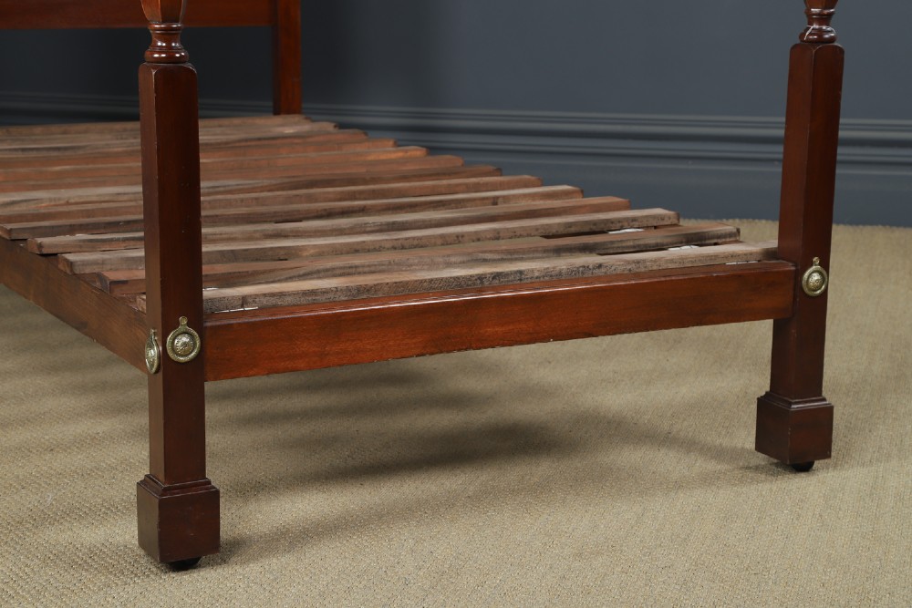 An Edwardian mahogany single four poster bed with turned posts, an arched canopy structure, and neutral drapery. View III