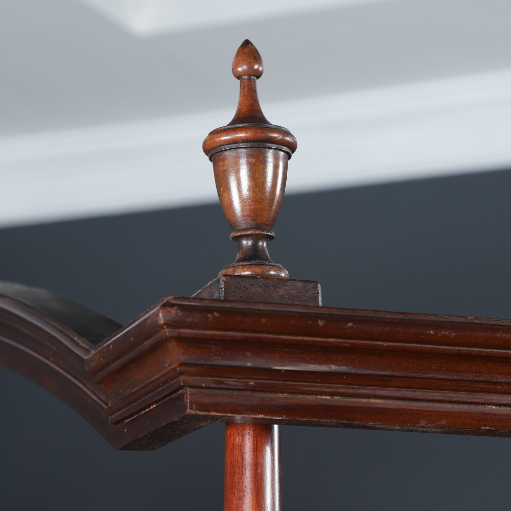 An Edwardian mahogany single four poster bed with turned posts, an arched canopy structure, and neutral drapery. View IX