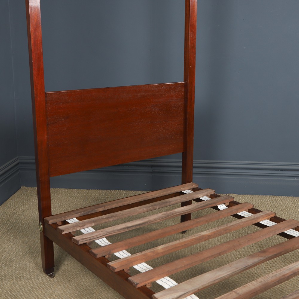 An Edwardian mahogany single four poster bed with turned posts, an arched canopy structure, and neutral drapery. View X