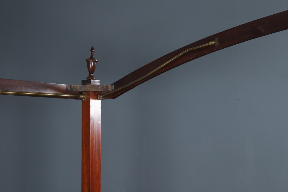 An Edwardian mahogany single four poster bed with turned posts, an arched canopy structure, and neutral drapery. View XII