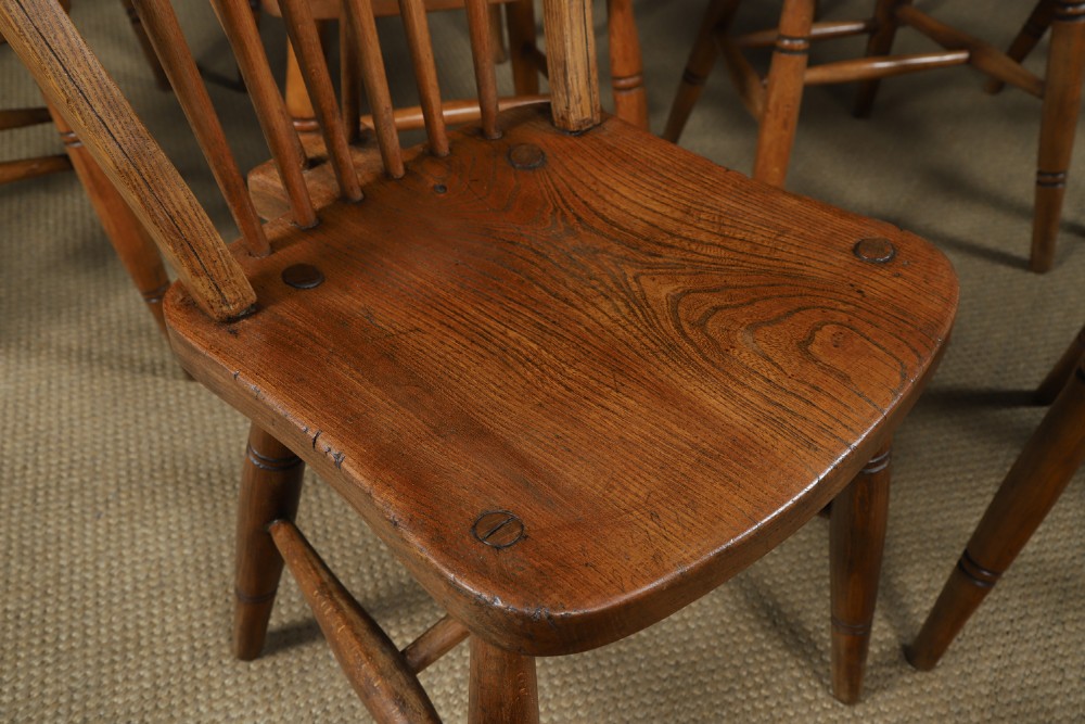 A set of twelve antique English ash and elm Windsor dining chairs with hoop stick backs and turned legs. View V
