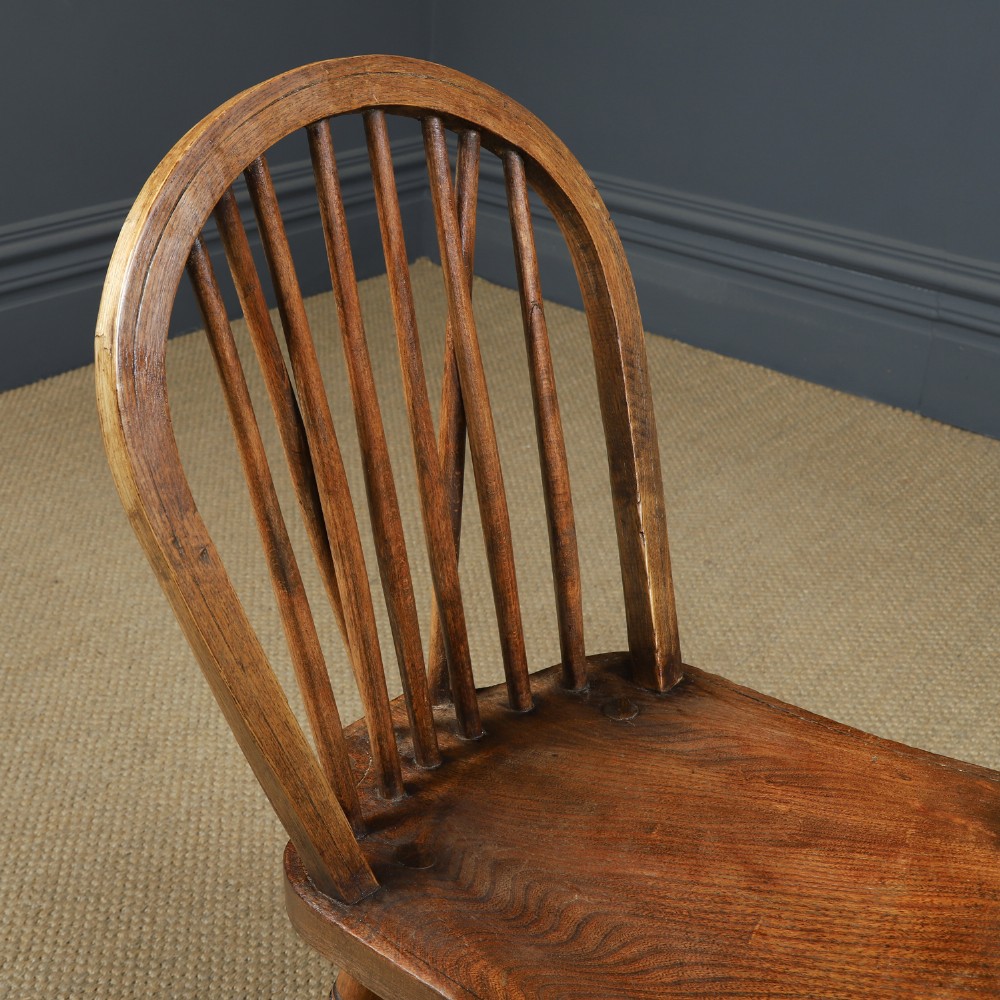 A set of twelve antique English ash and elm Windsor dining chairs with hoop stick backs and turned legs. View X