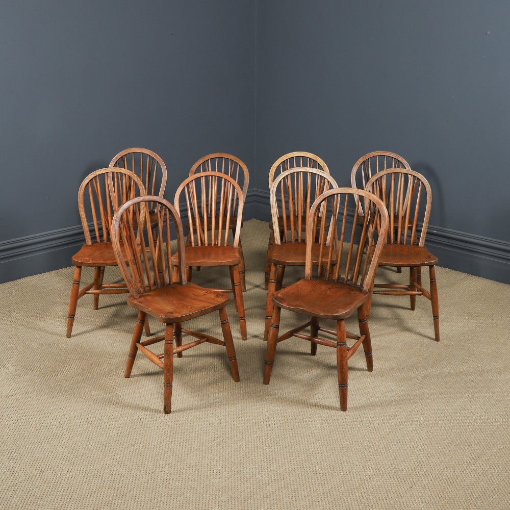 Set of ten warm brown ash and elm Windsor dining chairs with hoop and stick backrests.