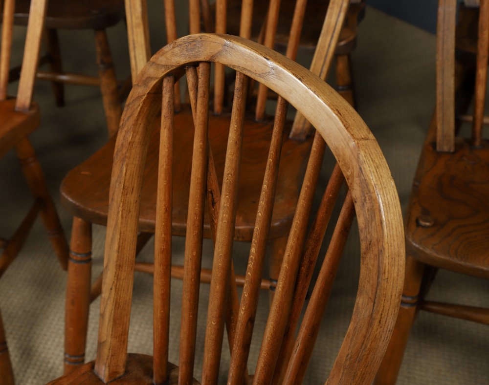 Set of ten warm brown ash and elm Windsor dining chairs with hoop and stick backrests. View III