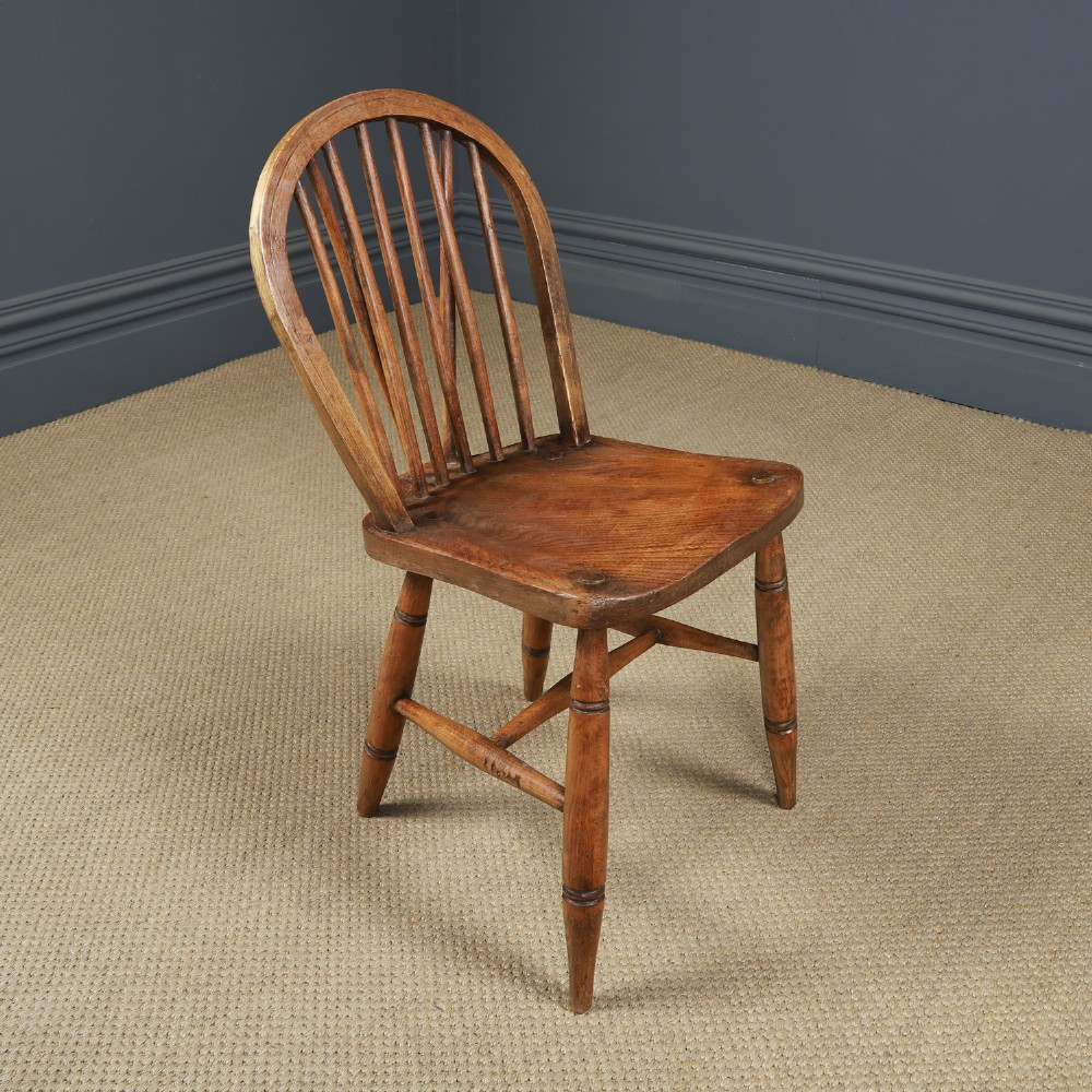 Set of ten warm brown ash and elm Windsor dining chairs with hoop and stick backrests. View VIII