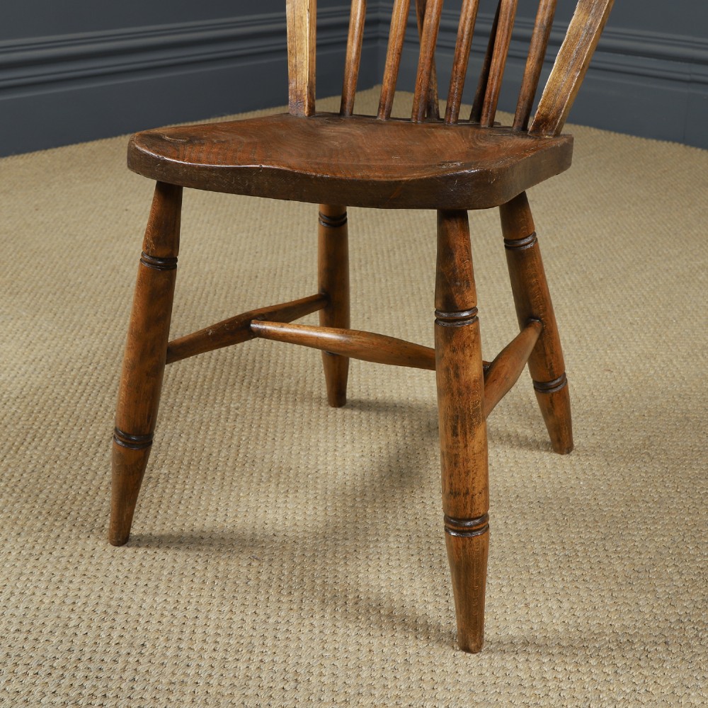 Set of ten warm brown ash and elm Windsor dining chairs with hoop and stick backrests. View IX