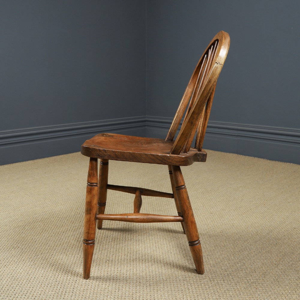 Set of ten warm brown ash and elm Windsor dining chairs with hoop and stick backrests. View XI
