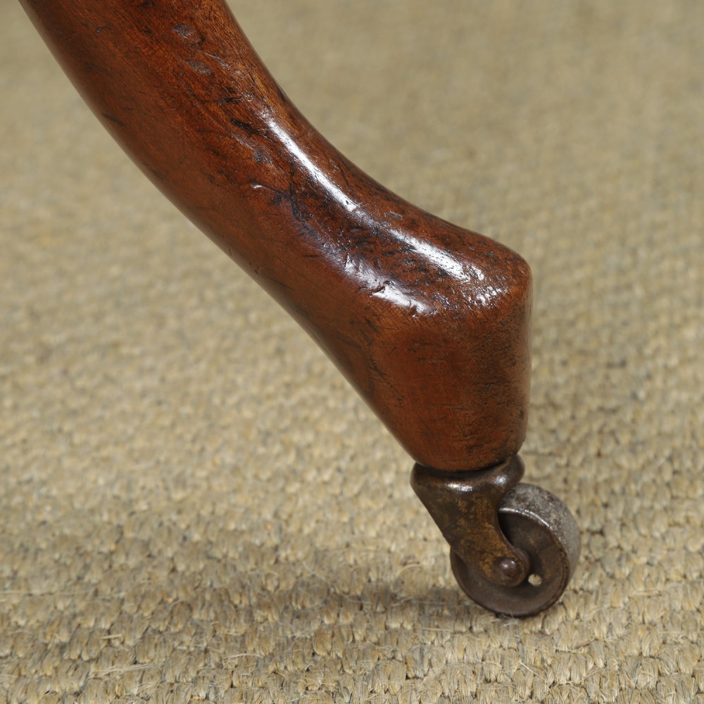 Victorian mahogany revolving desk armchair featuring a curved crest rail, pierced splat back, contoured wooden seat, and four legs with castors. View IV