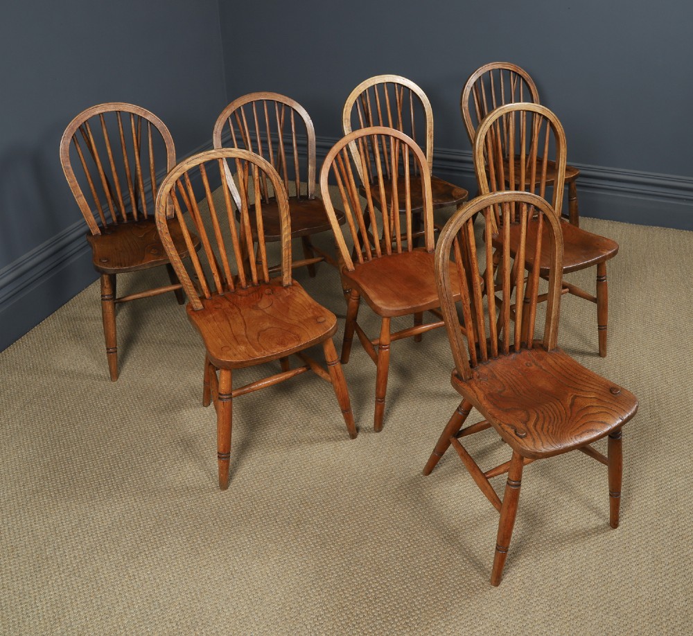 A set of eight antique Edwardian ash and elm Windsor dining chairs with arched hoop stick backs, shaped seats, and turned legs. View II