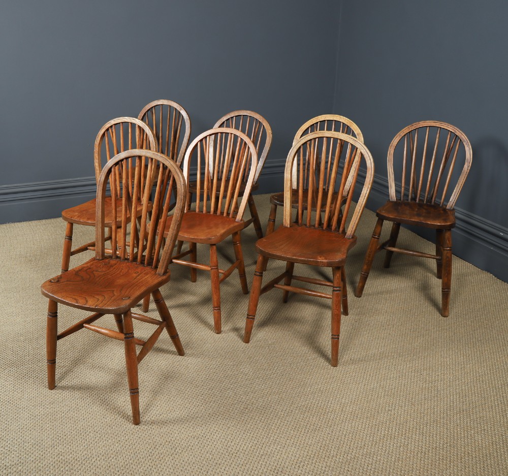A set of eight antique Edwardian ash and elm Windsor dining chairs with arched hoop stick backs, shaped seats, and turned legs. View IV