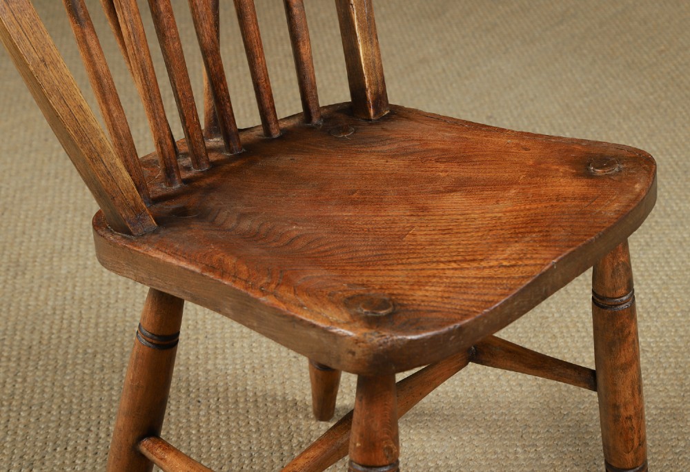 A set of eight antique Edwardian ash and elm Windsor dining chairs with arched hoop stick backs, shaped seats, and turned legs. View VII